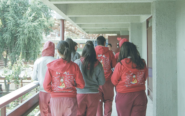 Estudiantes caminando por pasillo de colegio