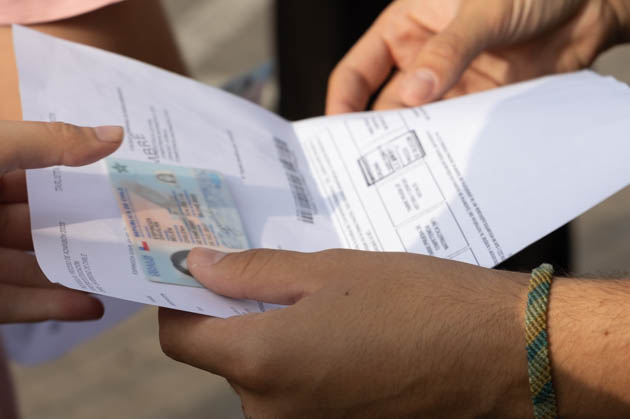 Postulantes mostrando su tarjeta de identificación y cédula de identidad en rendición paes.