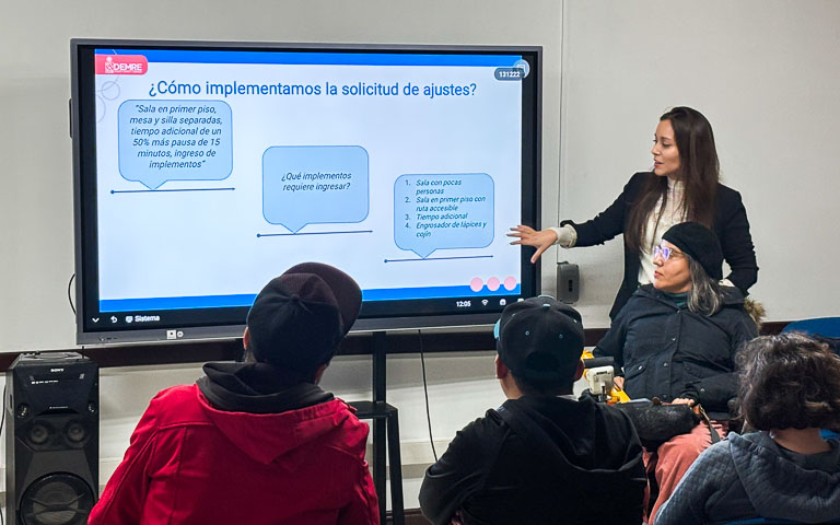 Profesional del DEMRE, Natalia Muñoz, entregando información sobre ajustes de pruebas a personas en situación de discapacidad.