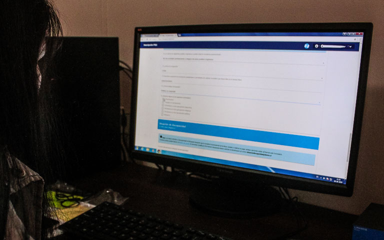 Estudiante frente a computador rellenando formulario de inscripción para la PAES