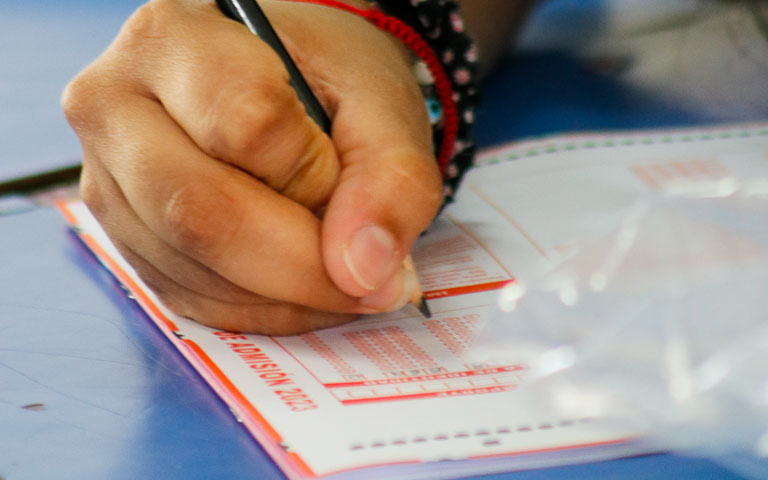 Postulantes completando datos de identificación en hoja de respuestas PAES.